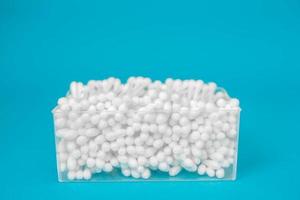 Cotton buds in plastic transparent rectangular container on a blue background photo