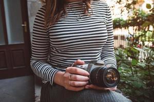 niña sosteniendo una cámara retro y tomando una foto