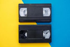 Two video tapes on yellow and blue background photo