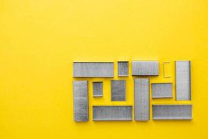 Metal staples for stapler on yellow background photo