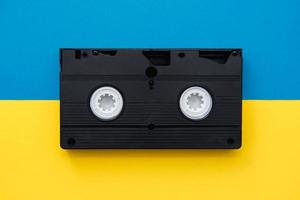 Video cassette on yellow and blue background photo