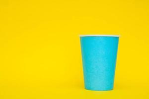 vaso de papel azul sobre fondo amarillo
