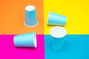 Vasos desechables de papel azul sobre un hermoso fondo multicolor foto