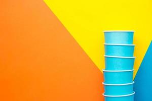 Blue paper disposable cups on beautiful multicolored background photo