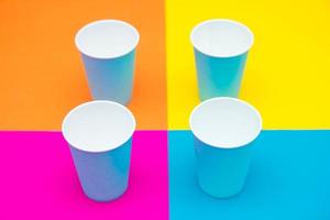 Vasos desechables de papel azul sobre un hermoso fondo multicolor foto