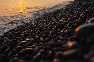 pequeñas piedras junto al mar con efecto bokeh