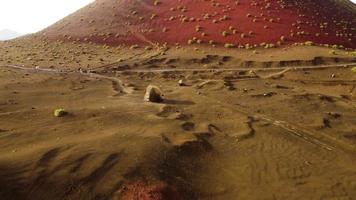 Video de drone de un volcán rojo y sus rocas en lanzarote, en las islas canarias, españa.