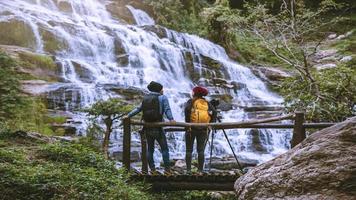 couples travel relax to photograph the waterfalls beautiful. In the winter. at the waterfall mae ya chiangmai in thailand. travel nature. summer photo