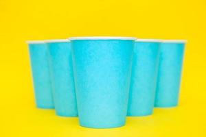 Pirámide de vasos desechables de papel azul sobre fondo amarillo foto