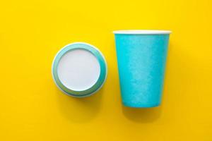 Two blue paper cups on yellow background photo