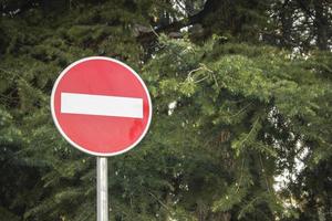 Red prohibition sign on green forest background. photo