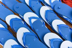 Flip flop azul y blanco sobre fondo de madera - zapatillas chanclas foto