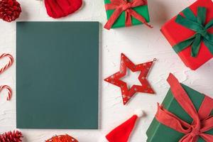 blackboard with christmas gift box and decor ornament on white concrete table photo