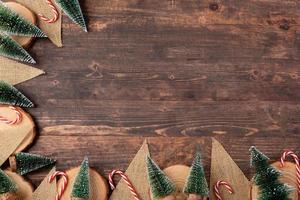 Christmas wood log plate and kraft flag and xmas tree on brown wooden table photo