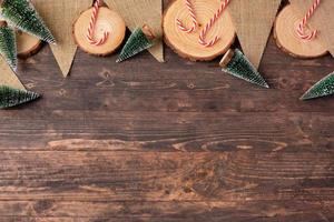 Christmas wood log plate and kraft flag and xmas tree on brown wooden table photo