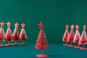 christmas tree red color with star pine tree group on green background with space photo