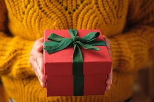 woman holding christmas red present for gift giving on xmas day photo