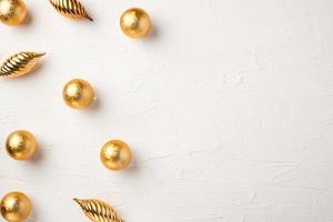 Christmas gold bauble ball decoration on white pastel table background photo
