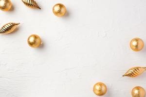 Christmas gold bauble ball decoration on white pastel table background photo