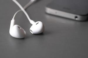 smart phone and headphone on wooden background . photo