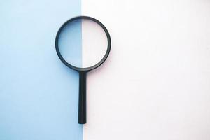 open book and magnifying glass on table. photo