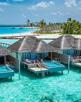 paisaje del paraíso de maldivas. paisaje aéreo tropical, paisaje marino, villas de agua con increíble mar y playa de laguna, naturaleza tropical. banner de destino de turismo exótico, vacaciones aéreas de verano, vista de drone foto