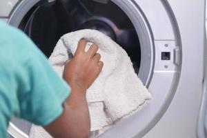 putting towel and cloths in a washing machine. photo