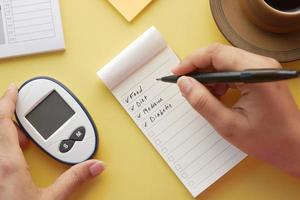 check mark on a check box on a paper with glucose meter on table photo