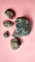Schist Mica metamorphic rock foliated structure on pink background. With quartz, muscovite, garnet, chlorite, calcite, apatite on Melange tectonic zone in Karangsambung, Indonesia. Ophiolite area photo