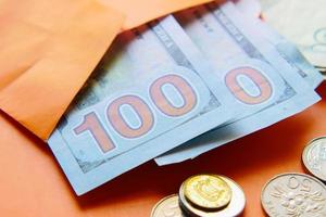 Close up of cash and coins in a envelope on table photo