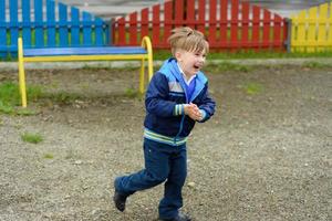 increíble niño ucraniano corriendo por el patio de recreo foto