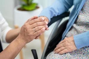 Tomados de la mano anciana asiática o anciana paciente con amor, cuidado, ánimo y empatía en la sala del hospital de enfermería, concepto médico fuerte y saludable foto