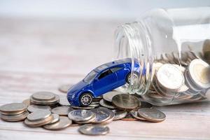Car on coins background Car loan, Finance, saving money, insurance and leasing time concepts. photo