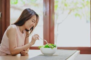 Healthy woman eating salad photo