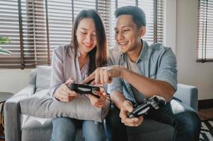 Asian couple having fun playing video game photo