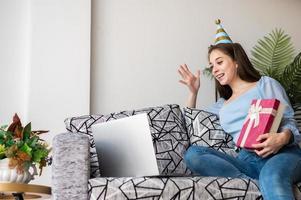 Woman celebrating birthday online at home photo