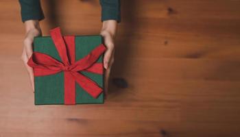 Top view of hand holding green Christmas gift box photo