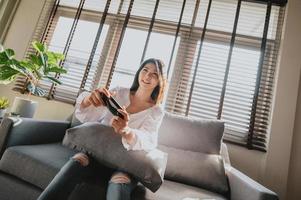 Asian woman playing video game at home photo