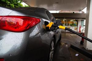 el coche se reposta en la gasolinera. reabastecimiento de combustible de automóvil con gasolina o diesel con un dispensador de combustible. foto