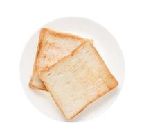 Rebanadas de pan tostado en un plato sobre fondo blanco. foto