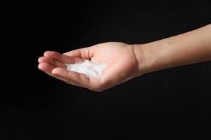 Hand holding sea salt on black background photo