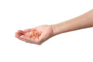 Hand holding pink salt on white background photo