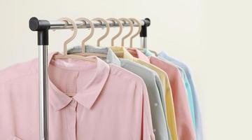 Pastel shirts hanging on rack in shop and freespace for text photo