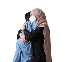 Young Muslim woman hugging and smiling with her little son on white background photo