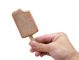 Mano sujetando helado de chocolate sobre fondo blanco. foto