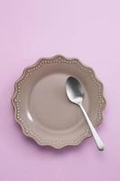 spoon in ceramic dish on pastel background photo