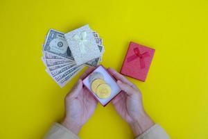 Hand holds a new year gift of money and bitcoin photo