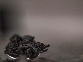 black tea leaves on metal spoon photo