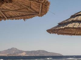 Techo de paja de sombrilla de playa y cielo azul foto