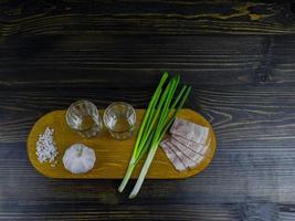 two empty glasses of vodka on a wooden board photo